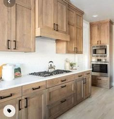 a kitchen with wooden cabinets and white counter tops, along with stainless steel stove top oven