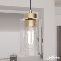 a light that is hanging from the ceiling in a room with white walls and cabinets