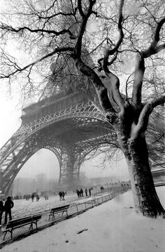 the eiffel tower in winter with people walking around