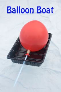 a red balloon floating on top of a black box with a stick sticking out of it