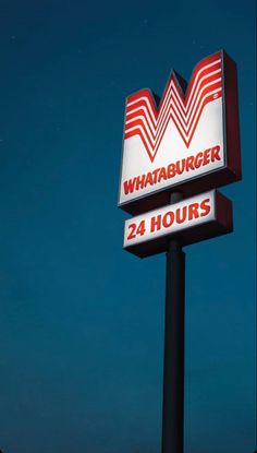 the sign for whataburgr 24 hours is lit up in the night sky