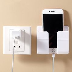 an iphone plugged in to a wall charger next to a power strip and socket