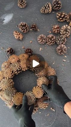 someone is making a wreath out of pine cones