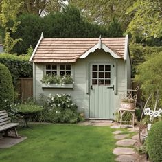 a small garden shed in the middle of a yard with stepping stones leading to it