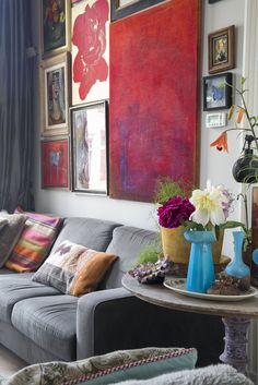 a living room filled with furniture and pictures on the wall above it's coffee table