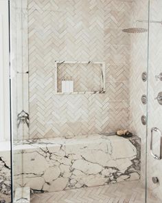 a marble bathtub and shower in a bathroom