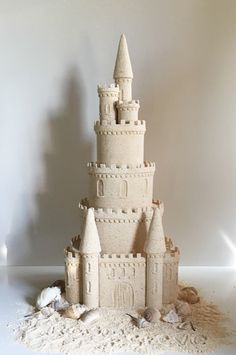 a sand castle made to look like it's been built on the beach with shells