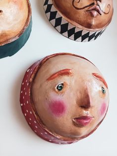 three clay faces sitting on top of each other