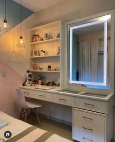 a room with a desk, mirror and lights on it's shelves in front of a window