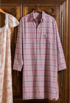 a pink and white shirt hanging on a wooden door next to a dress hanger