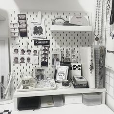 a white desk topped with lots of personal items and pictures on it's wall