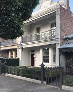 a white house with a black fence in front of it