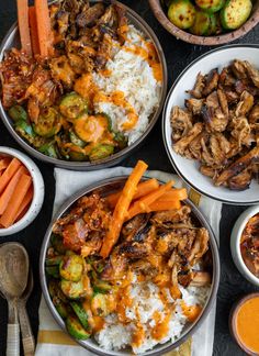 three bowls filled with different types of food on top of a black tablecloth next to silverware