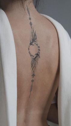 the back of a woman's neck with an arrow and stars tattoo on it