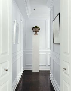 an empty hallway with white walls and wood floors