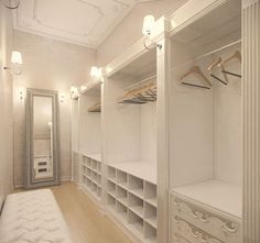 a walk in closet with white walls and shelving units on both sides, along with a bench