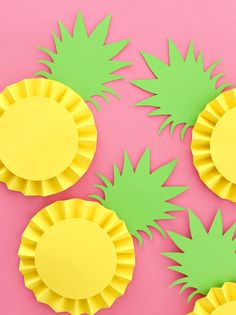 pineapple cupcake liners with green and yellow paper cutouts on pink background