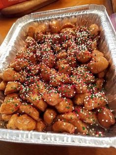 a tray filled with lots of donuts covered in sprinkles on top of a table