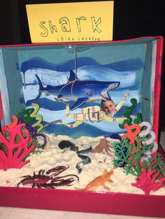 an ocean scene made out of cardboard with a shark and corals on the bottom