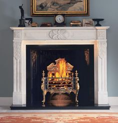 a fire place with a painting on the wall above it and a fireplace in front of it