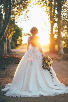 a woman in a wedding dress is walking down the road