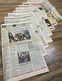 a bunch of newspapers laying on top of a wooden table