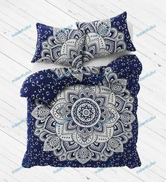 a blue and white comforter set with an intricate flower design on the pillow cover