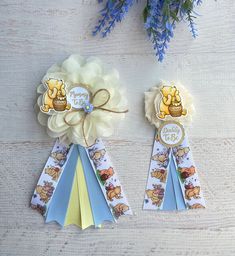 two award ribbons with winnie the pooh characters on them and blue flowers in the background