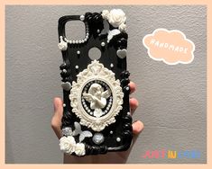 someone is holding up their phone case with pearls and flowers on the front, which has a clock in the middle