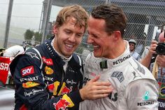 two men hugging each other in front of a fence and people taking pictures with their cell phones