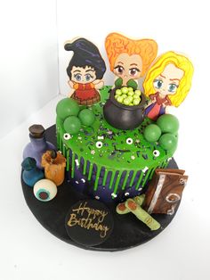 a birthday cake decorated with cartoon characters on it's top and green icing