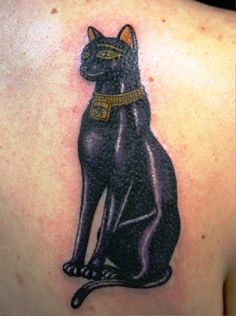 a black cat tattoo on the back of a woman's upper arm and shoulder