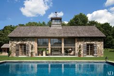 a house with a pool in front of it and an open patio area next to it