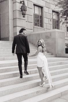 a man and woman walking up some steps holding each other's hand as they hold hands