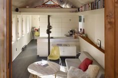 an open living room and kitchen area with white walls, wood flooring and vaulted ceiling