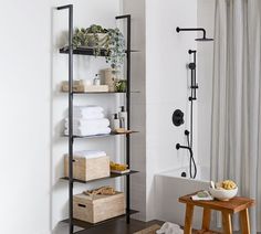 a bathroom with white walls and black shelving unit in the corner next to a bathtub