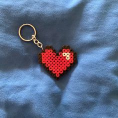 a heart shaped keychain on a blue blanket