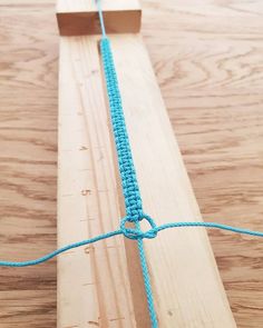 a piece of wood with a blue string attached to it