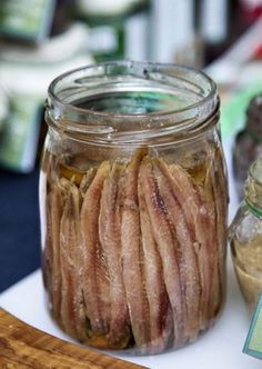 a jar filled with sliced meat sitting on top of a table