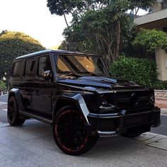 a black mercedes g class parked on the street