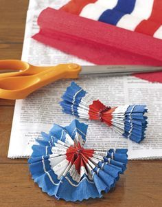 two red, white and blue pinwheels next to scissors on a piece of paper