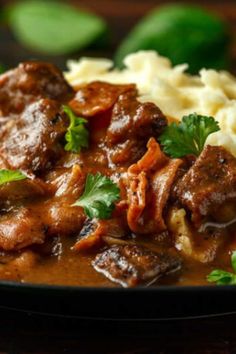 a close up of a plate of food with meat and mashed potatoes