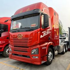 two red semi trucks parked next to each other