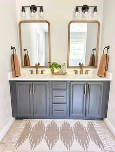 a bathroom with two sinks, mirrors and rug on the floor in front of it