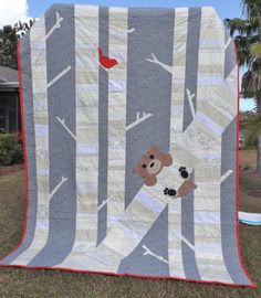 a teddy bear is on the tree quilt