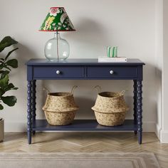 a blue table with two baskets under a lamp