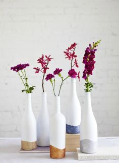 four white vases with purple flowers in them