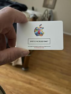 a person holding up an apple card in their hand, with the logo on it