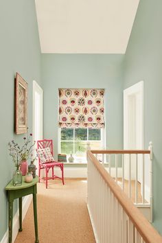 a hallway with blue walls and white trim, carpeted flooring and wooden railings