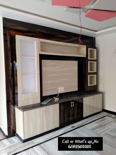 a living room with a large entertainment center in it's center wall, and shelving unit on the other side